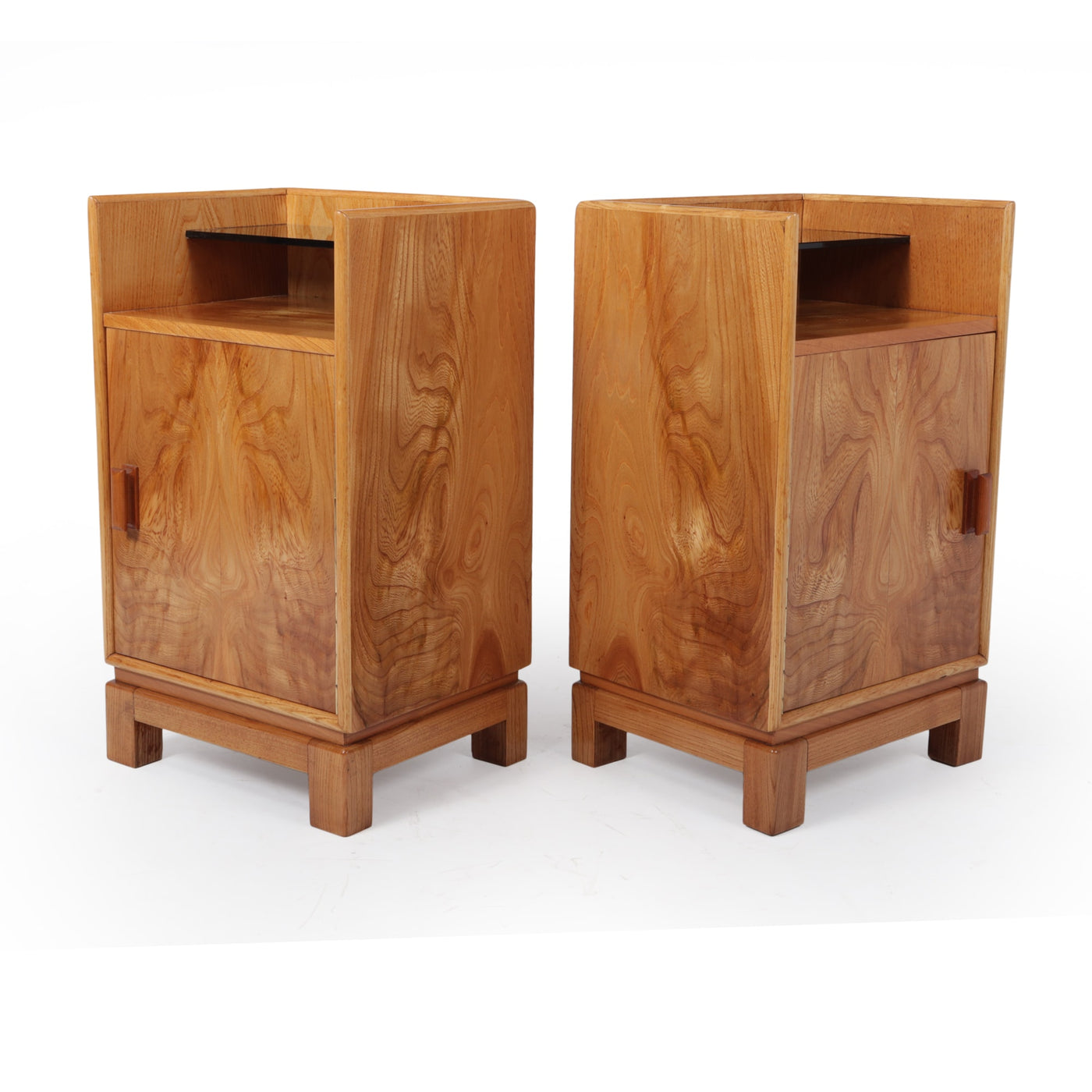 A Pair of Scandinavian Art Deco Bedside Cabinets c1930 A pair of Figured Elm bedside cabinets, having a raised black glass shelf over a single enclosed cupboard and standing on a very sturdy mortice jointed four legged base, the cabinets are offered in fully restored condition that have been newly polished and waxed with everything working as it should the cabinets are original and from the 1930’s so will have some slight age related marks